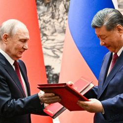 Ruský prezident Vladimir Putin (vľavo) a jeho čínsky náprotivok Si Ťin-pching pri výmene podpísaných dokumentov vo Veľkej sieni ľudu v Pekingu 20. mája 2026
